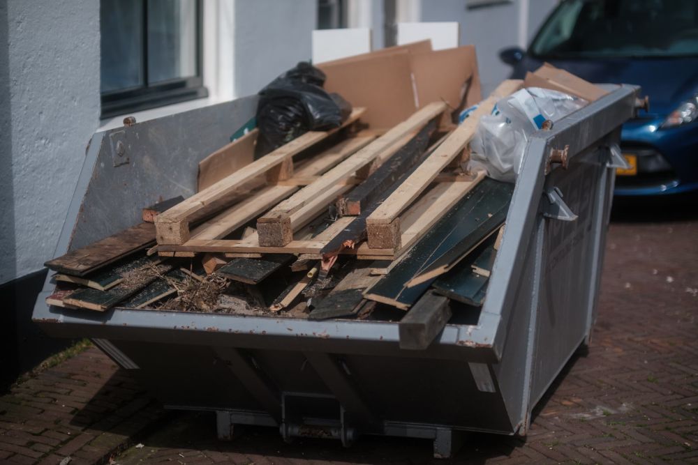 A dumpster packed with wood and other debris, showcasing a specialized junk removal service based in San Francisco, CA.